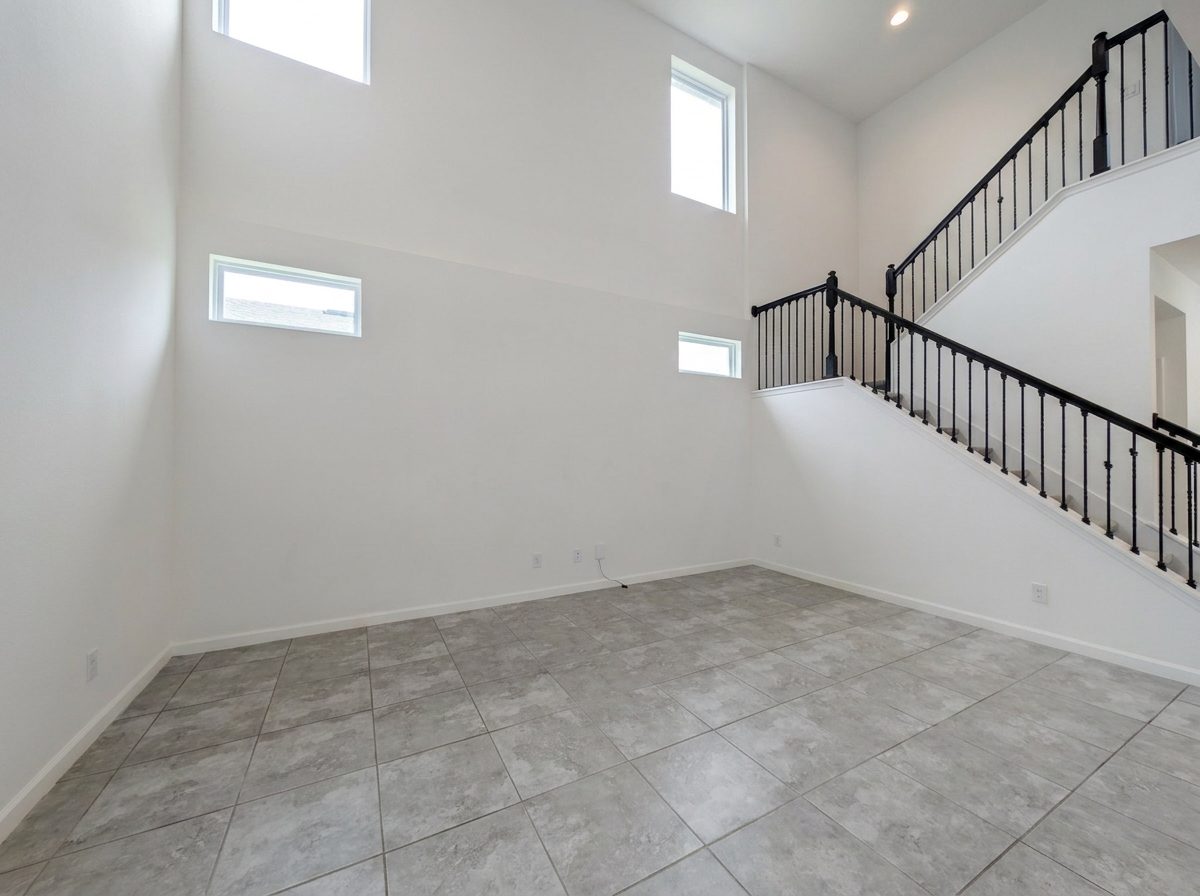 Two-story great room with a wall of tall windows and a modern black-railed staircase at 2275 Abilia Aly in Apopka's Silver Oak community