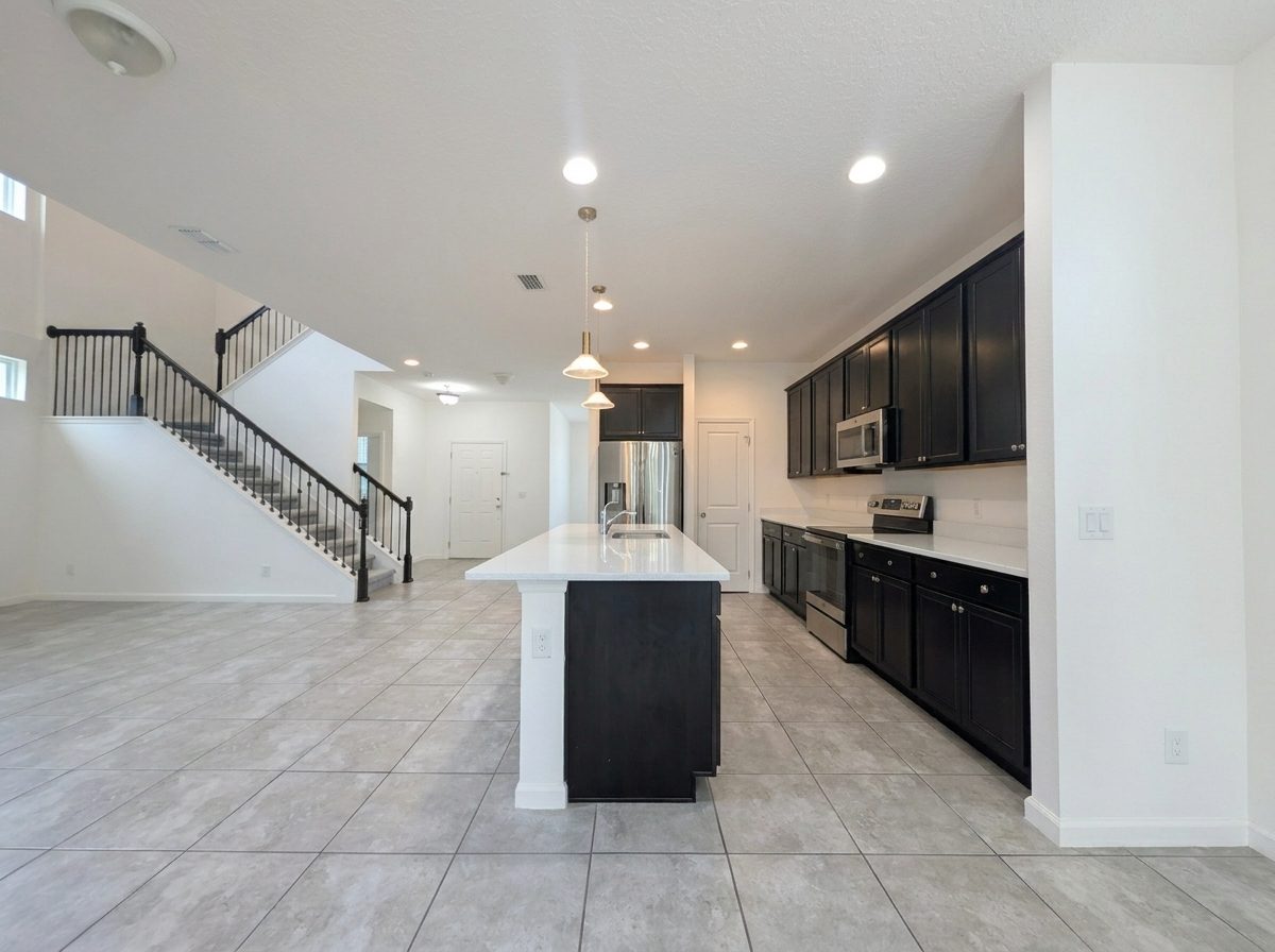 Open-concept great room and kitchen beneath a two-story ceiling at 2275 Abilia Aly, Apopka