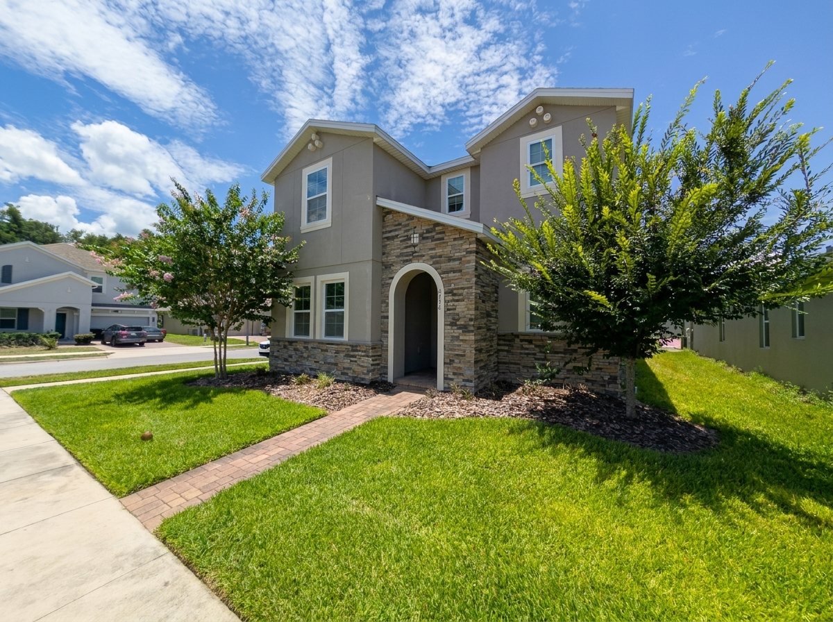 Front exterior of 2275 Abilia Aly — a two-story stucco-and-stone home in Apopka's Silver Oak community with a paver walkway and manicured lawn